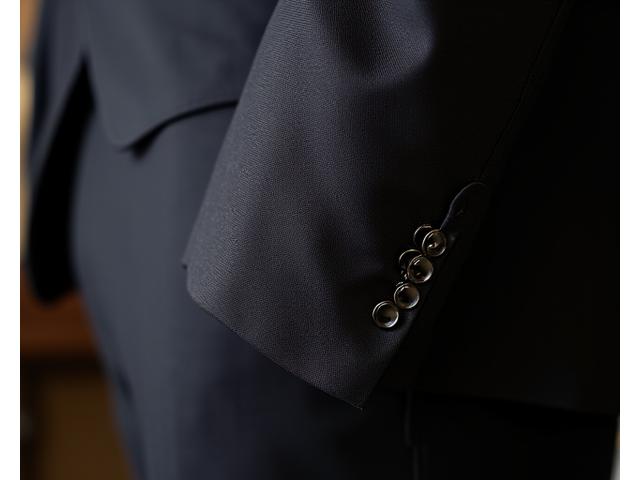 Detail shot of a well-pressed custom suit jacket, showing a flawless lapel and buttonhole.